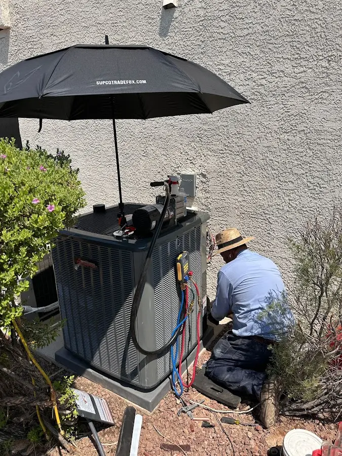 HVAC technician performing outdoor AC maintenance in Aztec